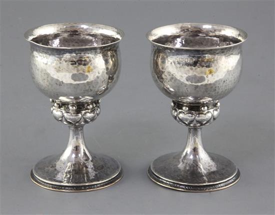 A pair of Omar Ramsden and Alwyn Carr silver goblets, London 1913, the stems with beading and heart motifs